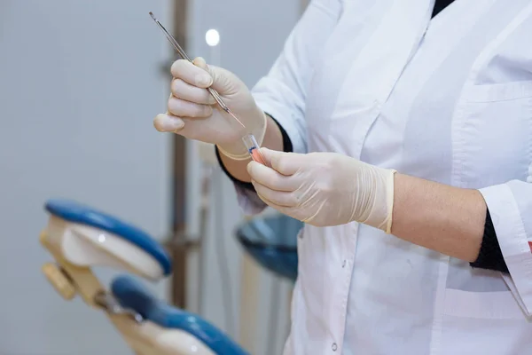 Médico dentista mão segurando ferramentas médicas em consultório odontológico. Conceito de saudável — Fotografia de Stock
