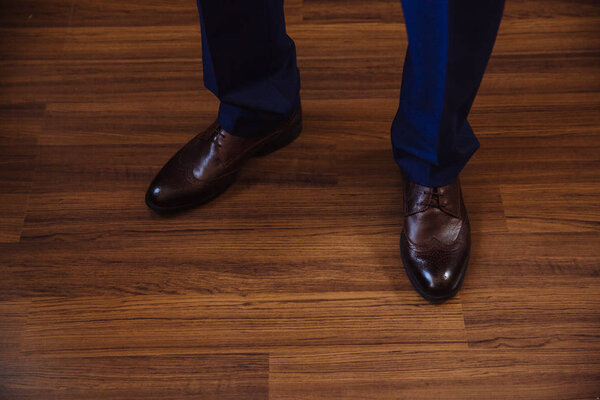 Business man dressing up with classic, elegant shoes. Groom wearing on wedding day, tying the laces and preparing.