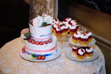 Tatlı çok düzeyli düğün pastası güzel çiçeklerle süslenmiş. Şeker çubuğu