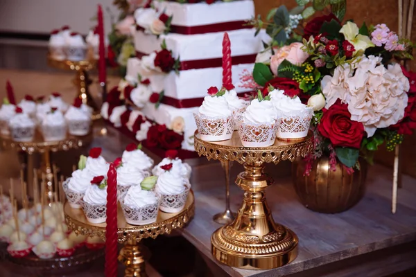 Barre à bonbons, couleur rouge, marsala. Table avec gâteau de mariage, bonbons, bonbons, dessert, pops . — Photo