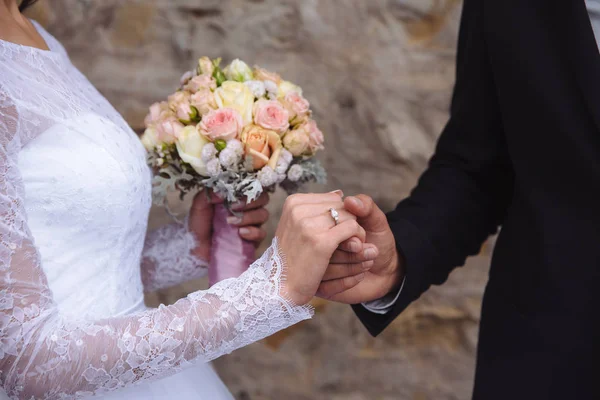 Braut und Bräutigam Hände mit Trauringen auf braunem Tisch — Stockfoto