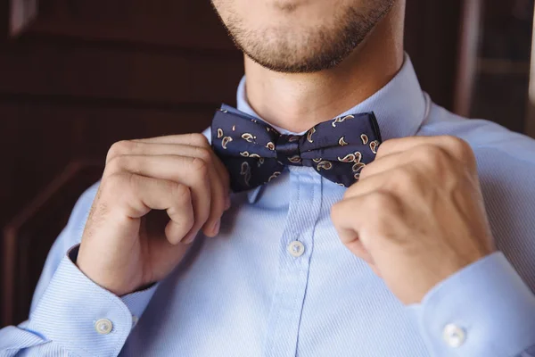 Eller dokunuşlar papyon bir takım elbise üzerinde mans