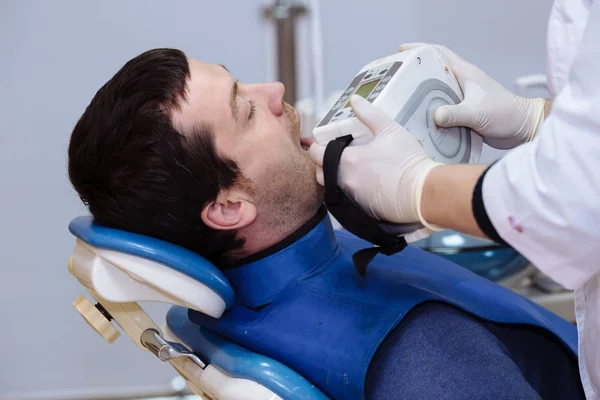 Dentista médico de mano sosteniendo herramientas médicas en el consultorio dental cerca de la cara del paciente. Concepto de saludable — Foto de Stock