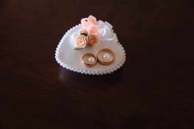 Yastık kahverengi arka plan, beyaz altın alyans süslemeleri