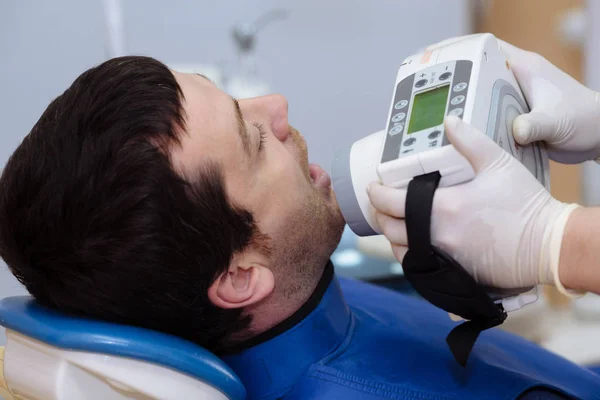 Médico dentista mão segurando ferramentas médicas em consultório odontológico perto do rosto do paciente. Conceito de saudável — Fotografia de Stock