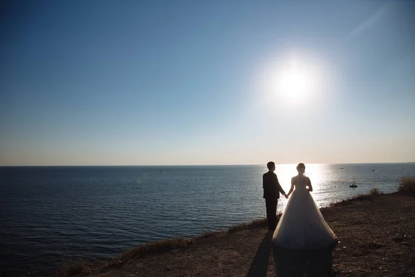 Marié et mariée se tiennent la main au coucher du soleil, le jour du mariage. Concept de famille d'amour — Photo