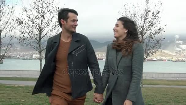 Pareja joven caminando por la playa en el mar. Abrazos y besos. Concepto familia y amor — Vídeos de Stock