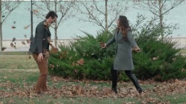 Yavaş sonbahar parkta oynarken ve atma genç mutlu çift yaprakları