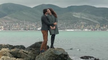 Genç bir çift deniz plaj yürüyüş. Sarılma ve öpüşme. Aile ve sevgi kavramı