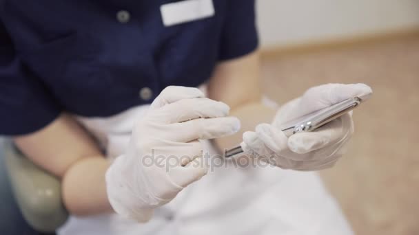 女性歯科医のテキスト メッセージやスマート フォン上でチャットの手。クローズ アップ シーン — ストック動画