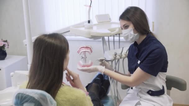 Tandarts procedures maakt en behandelen van tanden voor een mooie geduldige vrouw in tandheelkundige kliniek. Begrip van gezond leven — Stockvideo