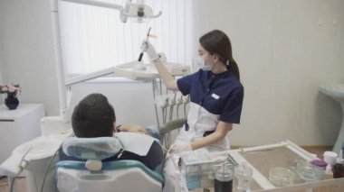 Genç kız dişçi diş erkek hasta yordamlarla yapma. Doktor Diş davranır. Kavramı çok sağlıklı yaşam