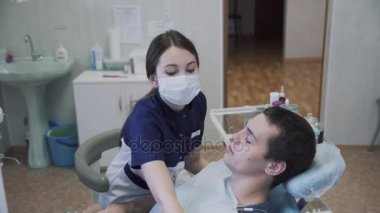 Dişçi genç kadın erkek hastaya diş ofisinde yordamlar yapma. Sağlıklı yaşam kavramı