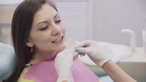 Dentista faz procedimentos e tratar os dentes para uma bela mulher paciente na clínica odontológica. Conceito de vida saudável. Fechar cena — Vídeo de Stock