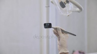 Genç kadın dişçi ofisinde hastalar için X-Ray gösteren. X-ışını fotoğrafa odaklan. Olay yerini kapatın