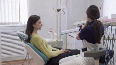 güzel kadın dişçi diş Kliniği yordamlarda hastaya hazırlar, göğüs Steril bez koyar. Heatlhy hayatı kavramı.