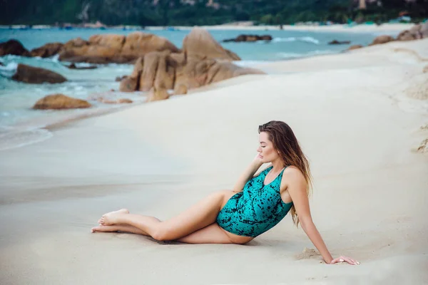 Schöne junge brünette Frau im blauen Bikini posiert am Strand. sexy Model Portrait mit perfektem Körper. Konzept der Sommerferien. — Stockfoto