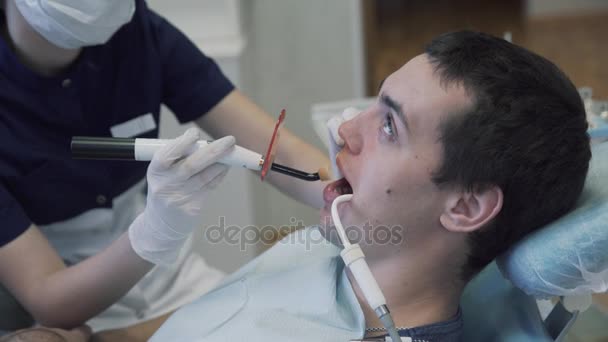 Zahnärztin junge Frau macht Eingriffe zu Männern Patientin in Zahnarztpraxis. Konzept des gesunden Lebens — Stockvideo