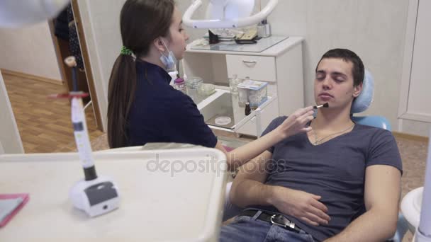 Mujer joven haciendo maquillaje para hombre en su lugar profesional. Concepto de belleza — Vídeos de Stock