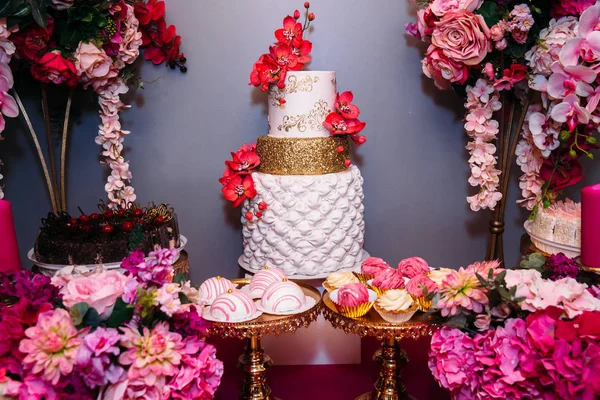 Słodki tort weselny wielopoziomowe ozdobione pięknymi kwiatami. Candy bar — Zdjęcie stockowe