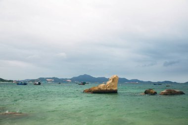 Güzel manzara okyanus, mükemmel kumsal, büyük taşlar, ağaçlar, masmavi su manzaralı. Arka plan görüntüsü. Kavram seyahat