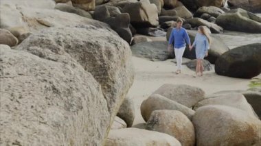 Sevgili, mavi giysili genç mutlu bir güzel çift el, gülüyor, gülüyor sahil yürüyüş tutuyorsun. Balayı Tarih ve mutluluk aile kavramı