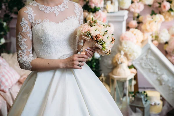 Nahaufnahme von Brauthänden, die einen wunderschönen Hochzeitsstrauß mit weißen und rosa Rosen halten. Konzept der Floristik — Stockfoto