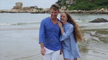 Ağır çekim adam kız el ve onu öpmeye tarafından tutar. Plaj, konuşma ve gülümseme yürüyorlar