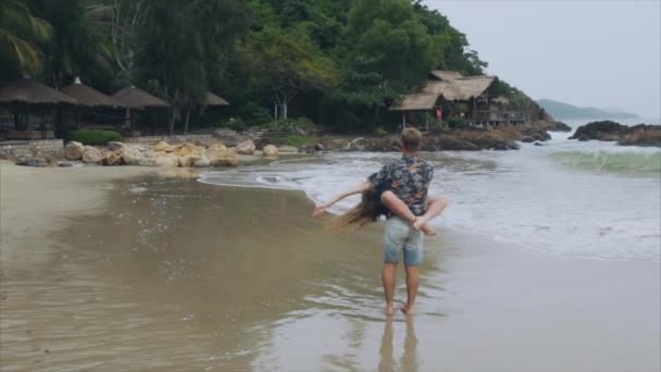 남자 여자 보유 그의 팔에 슬로우 모션으로 바다 해변에 사랑 소용돌이에 젊은 부부. 행복 한 가족 및 나머지의 개념 — 비디오
