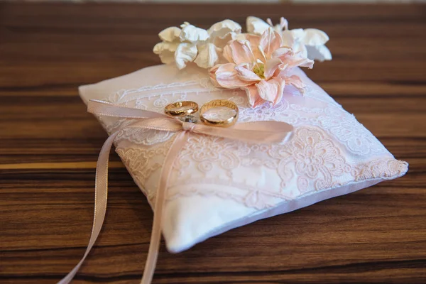 Bagues de mariage en or sur coussin décoré blanc sur fond en bois — Photo