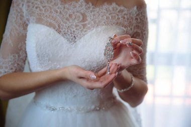 Earrind gelinin elinde. Zarif beyaz gelinlik