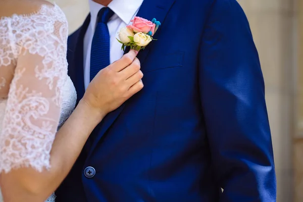 关闭固定胸花，夹克的新郎新娘手 — 图库照片