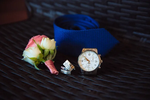 Gentleman accessory. Bouttonierre, watches, cufflinks, tie on dark background