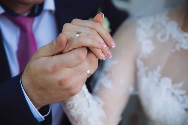 Ženich a nevěsta se drží za ruce na svatební den. Pojem lásky rodiny — Stock fotografie