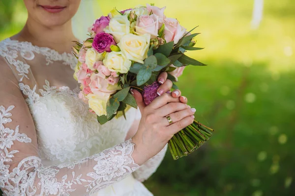 Primer plano de las manos de la novia sosteniendo hermoso ramo de bodas con rosas blancas y rosas rosadas. Concepto de florística —  Fotos de Stock