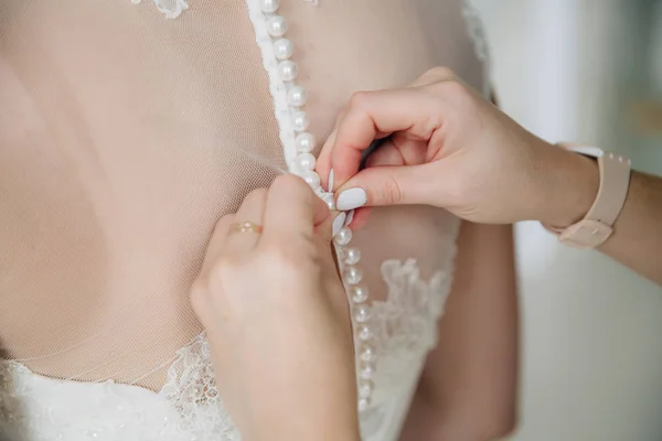 Женские руки пуговицы платье невесты в день свадьбы. Концепция одежды — стоковое фото