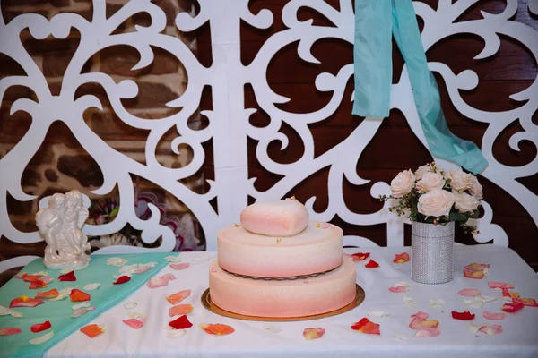 Wielopoziomowe tort weselny w tha postaci serca na biały stół. Słodycze w kolorze białym i różowym — Zdjęcie stockowe