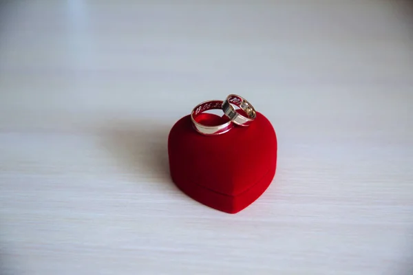 Bague de fiançailles dorée dans une boîte en forme de coeur sur fond blanc en bois — Photo