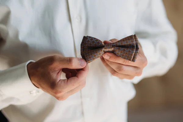 Closeup Groom mãos com laço. Roupa elegante cavalheiro, camisa branca e cinto marrom — Fotografia de Stock