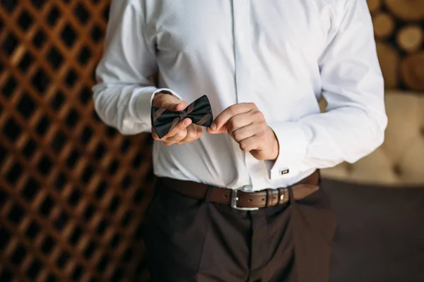 Manos de novio con pajarita. Elegante ropa caballero, camisa blanca y cinturón marrón —  Fotos de Stock