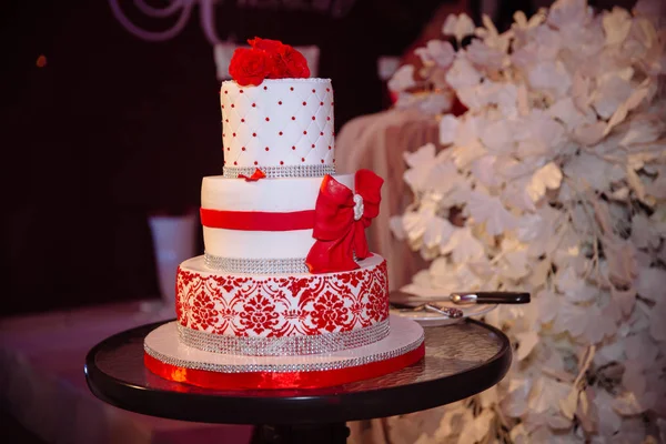 巨大的甜多层次结婚蛋糕装饰着鲜花。派对上糖果条的概念 — 图库照片