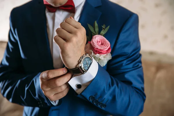 胸花的蓝色外套的人戴手表。首饰、 衣服的概念 — 图库照片