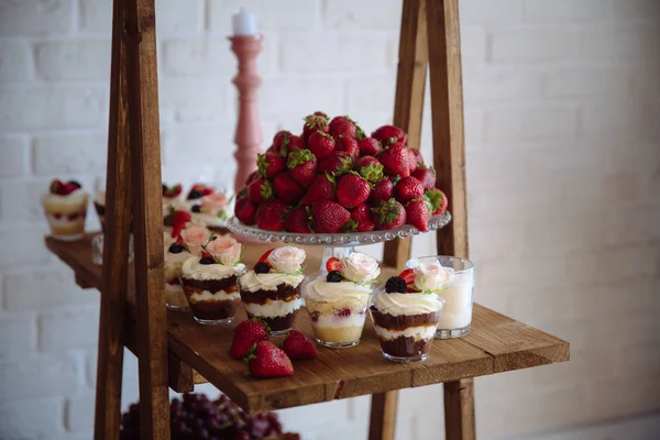 Una barra de caramelo. Mesa con dulces, buffet con cupcakes, dulces, postres . — Foto de Stock