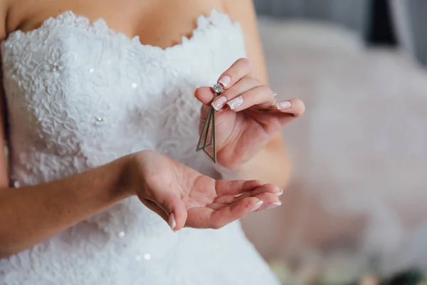 Серьга в руках невесты. Концепция ювелирных изделий — стоковое фото