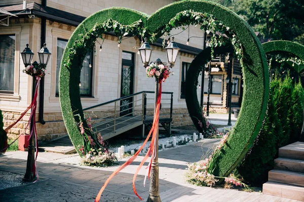 Arco cerimônia de casamento na forma de um coração, altar decorado com flores no gramado — Fotografia de Stock