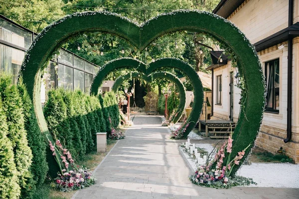 Hochzeitsbogen in Herzform, mit Blumen geschmückter Altar auf dem Rasen — Stockfoto