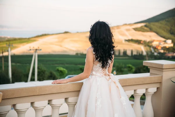 Vackra brud i en lyxig vit klänning, bakifrån. Havet vid bakgrund — Stockfoto