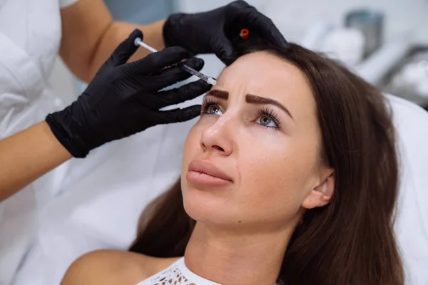 Feche o belo rosto feminino e mãos cosmetologists com seringa durante injeções de beleza facial. Picadas de botox, injeção de ácido hialurônico. Rejuvenescimento e hidratação. Conceito de cosmetologia — Fotografia de Stock