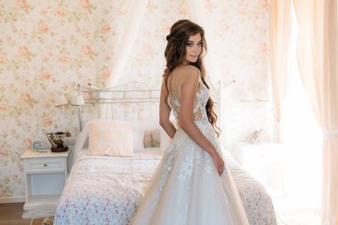 Güzel beyaz gelinlik içinde çekici gelin otel, sabah hazırlık gelin odasında duruyor. Giysi kavramı