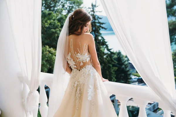 Hübsche Braut mit schönem Blumenstrauß in den Händen. attraktive junge Frau im weißen Kleid mit Hochzeitsschminke auf grünem Gras-Hintergrund. Nahaufnahme Porträt lächelnde Braut — Stockfoto